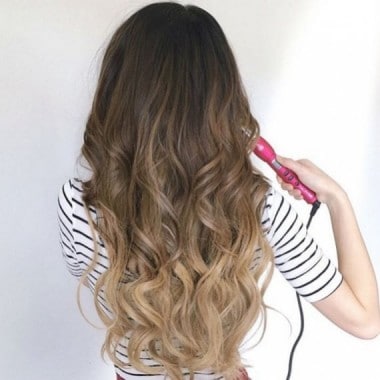 woman using a Hot Curling Iron Brush on long hair